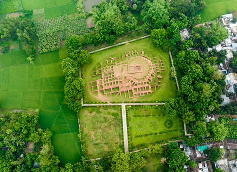 Aerial view of the ancient Gokul Medh archaeological site with its brick foundations surrounded by lush green fields and trees in Bogura Rajshahi Division Bangladesh.