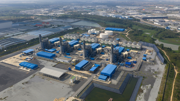 Aerial view of Gulf Pluak Daeng Power Plant with blue industrial buildings cooling towers and storage tanks in Map Yang Phon Rayong Thailand.