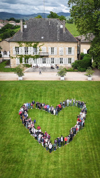 La Chapelle de Guinchay France 01 June 2024 Aerial view of a large group of people forming a heart shape on a green lawn in front of a historic manor house. La Chapelle de Guinchay France 01 June 2024 Aerial view of a large group of people forming a heart shape on a green lawn in front of a historic manor house.