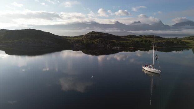 Aerial view of a sailboat on calm waters in Senja Norway. Aerial view of a sailboat on calm waters in Senja Norway.