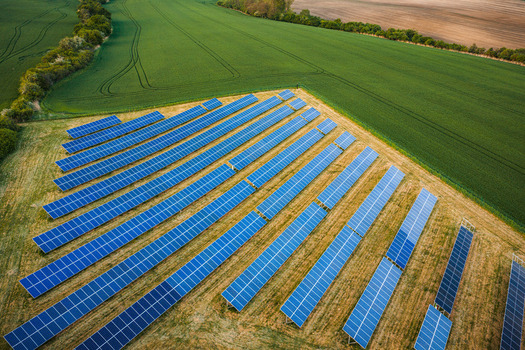 Aerial view of blue solar panels in a photovoltaic farm surrounded by green agricultural fields and trees in Chvalkovice Hradec Kralove Region Czechia.