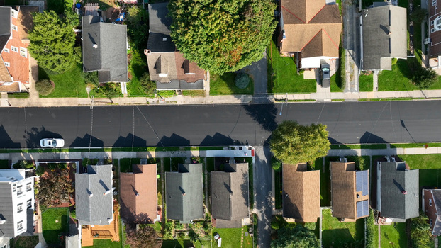 Aerial view of a residential street in Lebanon Pennsylvania United States featuring suburban houses with pitched roofs manicured lawns mature trees and a parked car along the road.