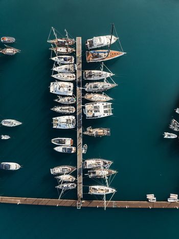 Aerial view of sailboats and yachts moored at a long wooden pier in the turquoise waters of the Island of Ortigia Syracuse Sicily Italy. Aerial view of sailboats and yachts moored at a long wooden pier in the turquoise waters of the Island of Ortigia Syracuse Sicily Italy.