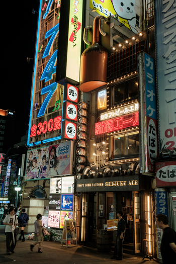 Shinjuku City Japan 30 September 2025 View of a vibrant building facade illuminated with neon signs and lights casting a warm glow onto the bustling street below. Shinjuku City Japan 30 September 2025 View of a vibrant building facade illuminated with neon signs and lights casting a warm glow onto the bustling street below.