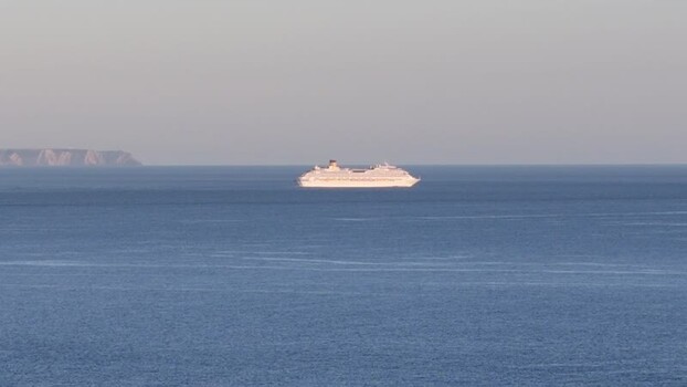 Aerial view of a large white cruise ship sailing on the calm blue sea Portugal.