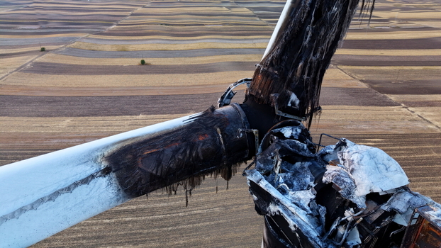 Aerial view of a damaged and burnt wind turbine blade and hub after a fire set against the backdrop of harvested agricultural fields in Vladimirovac Vojvodina Serbia.