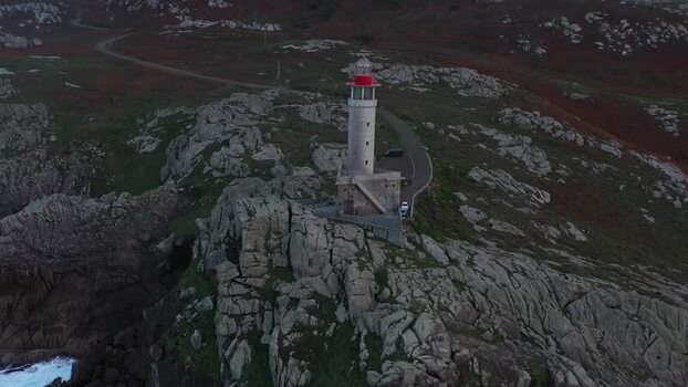 Aerial view of Faro de Punta Nariga on rocky cliffs Spain.