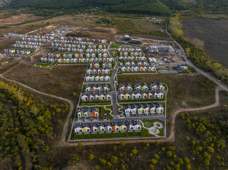 Aerial view of Residential Park Lozen featuring modern colorful townhouses with green lawns and paved streets surrounded by rural landscape in Sofia Sofia City Province Bulgaria. Aerial view of Residential Park Lozen featuring modern colorful townhouses with green lawns and paved streets surrounded by rural landscape in Sofia Sofia City Province Bulgaria.