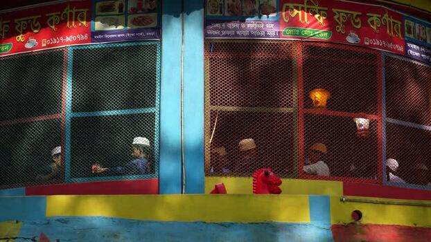 View of people behind mesh windows at a colorful shop Bangladesh. View of people behind mesh windows at a colorful shop Bangladesh.