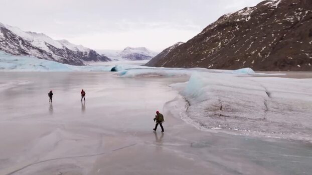 Aerial view of people walking on a frozen glacier lake Iceland. Aerial view of people walking on a frozen glacier lake Iceland.