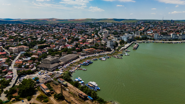 Aerial view of the Danube Delta waterfront with docked boats industrial warehouses and residential neighborhoods in Tulcea Tulcea Romania.