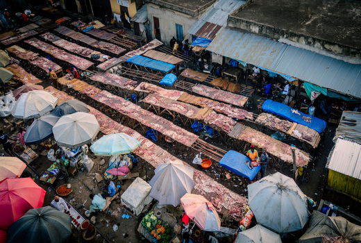 Aerial view of Panteka Market showing rows of outdoor stalls with meat products colorful umbrellas and vendors in a busy trading area in Kaduna Kaduna Nigeria. Aerial view of Panteka Market showing rows of outdoor stalls with meat products colorful umbrellas and vendors in a busy trading area in Kaduna Kaduna Nigeria.