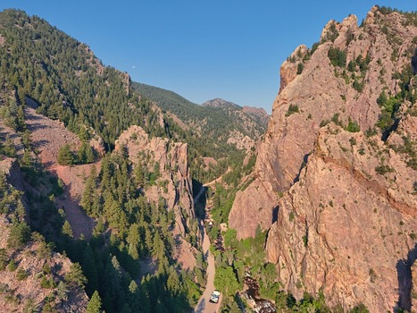 Aerial view of Eldorado Springs canyon with rugged rock formations dense pine forests and a winding road through the valley in Eldorado Springs Colorado United States.
