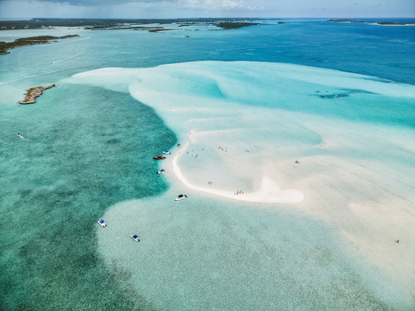 Aerial view of the Man O War Cay Sandbar with boats anchored in turquoise water and people enjoying the sun in Rolletown Exuma The Bahamas. Aerial view of the Man O War Cay Sandbar with boats anchored in turquoise water and people enjoying the sun in Rolletown Exuma The Bahamas.