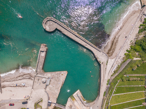 Aerial view of the historic stone harbour walls and turquoise water at Charlestown Harbour in Charlestown Cornwall United Kingdom. Aerial view of the historic stone harbour walls and turquoise water at Charlestown Harbour in Charlestown Cornwall United Kingdom.