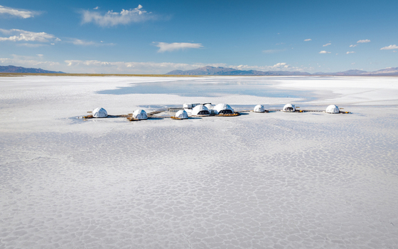 Aerial view of the white salt flats of Salinas Grandes featuring dome structures connected by walkways under a clear blue sky in La Poma Department Salta Province Argentina. Aerial view of the white salt flats of Salinas Grandes featuring dome structures connected by walkways under a clear blue sky in La Poma Department Salta Province Argentina.