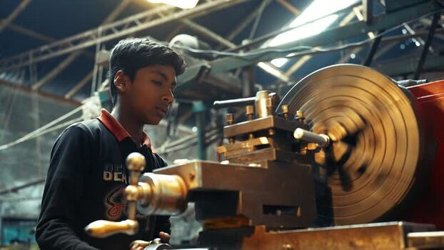 View of a young boy working on a lathe machine in Bogura Bangladesh.