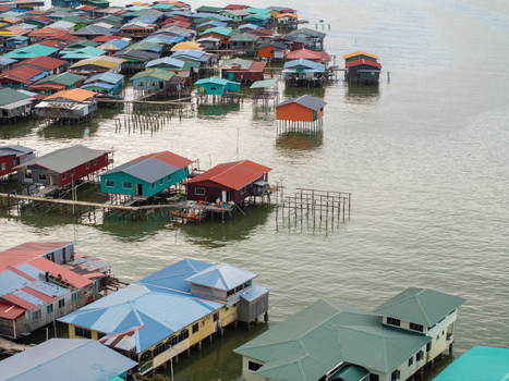 Aerial view of a vibrant water village with colorful stilt houses and wooden walkways over calm water in Kota Kinabalu Sabah Malaysia. Aerial view of a vibrant water village with colorful stilt houses and wooden walkways over calm water in Kota Kinabalu Sabah Malaysia.