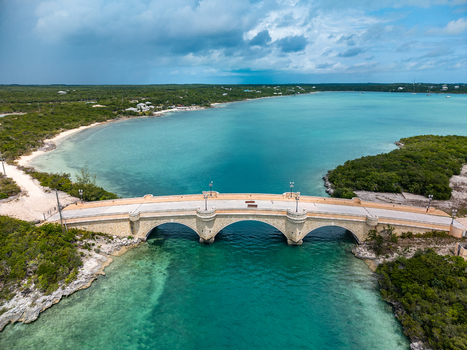 Aerial view of the stone bridge at Crab Cay spanning turquoise waters surrounded by lush tropical vegetation and sandy shores in Exuma Exuma The Bahamas. Aerial view of the stone bridge at Crab Cay spanning turquoise waters surrounded by lush tropical vegetation and sandy shores in Exuma Exuma The Bahamas.
