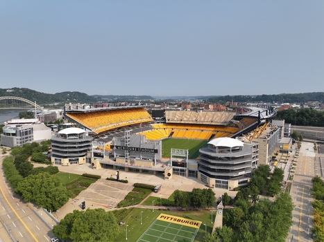 Pittsburgh Pennsylvania United States 26 July 2026 Aerial view of Acrisure Stadium with its distinctive yellow seating green field and surrounding urban landscape under a clear sky.