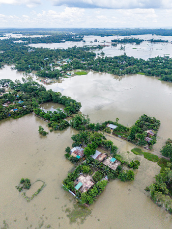 Aerial view of flooded rural landscape with houses surrounded by water and lush green trees in Banshkhali Upazila Chittagong Division Bangladesh. Aerial view of flooded rural landscape with houses surrounded by water and lush green trees in Banshkhali Upazila Chittagong Division Bangladesh.