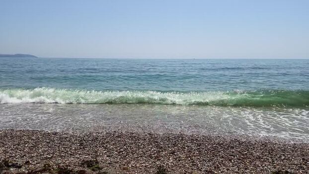 View of the pebble beach and waves in Charlestown United Kingdom. View of the pebble beach and waves in Charlestown United Kingdom.