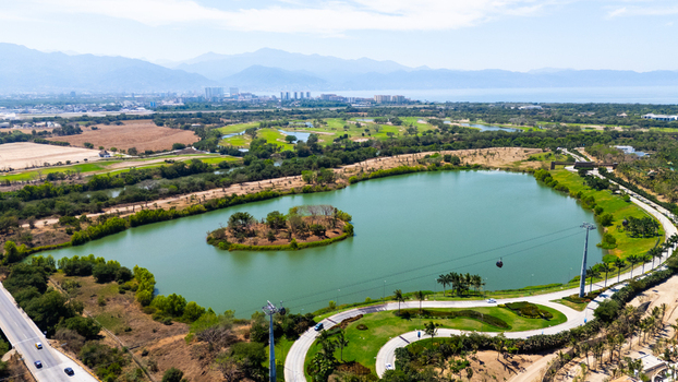 Aerial view of a serene lake reflecting the sky surrounded by lush greenery and distant mountains Puerto Vallarta Mexico