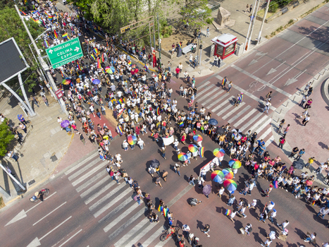 Guadalajara Jalisco Mexico 01 June 2019 Aerial view of the LGBT pride parade with a large crowd of people walking along the street carrying rainbow flags and umbrellas.