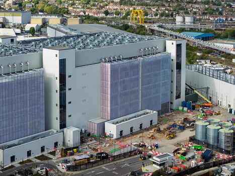 Aerial view of a large data center facility with industrial cooling units storage tanks and construction equipment in the United Kingdom. Aerial view of a large data center facility with industrial cooling units storage tanks and construction equipment in the United Kingdom.
