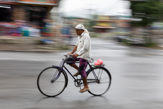 Pokhara Nepal 31 July 2026 View of a man riding a bicycle along a street in Pokhara captured with a motion blur effect.