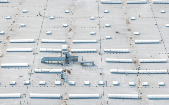 Aerial view of a large industrial building roof featuring numerous rectangular skylights and ventilation systems in Kowale Pomeranian Voivodeshi Poland. Aerial view of a large industrial building roof featuring numerous rectangular skylights and ventilation systems in Kowale Pomeranian Voivodeshi Poland.