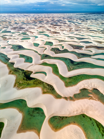 Aerial view of Lagoa Bonita featuring vast white sand dunes interspersed with vibrant green rainwater lagoons in Barreirinhas State of Maranhao Brazil. Aerial view of Lagoa Bonita featuring vast white sand dunes interspersed with vibrant green rainwater lagoons in Barreirinhas State of Maranhao Brazil.