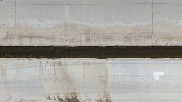 Aerial view of the concrete channel of the Los Angeles River with flowing water and weathered concrete walls in Los Angeles California United States.