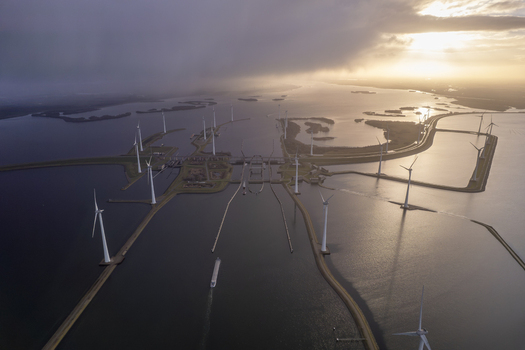 Aerial view of the Krammer locks featuring wind turbines water channels and a cargo ship navigating the waterway under a dramatic sunset sky in Bruinisse Zeeland Netherlands. Aerial view of the Krammer locks featuring wind turbines water channels and a cargo ship navigating the waterway under a dramatic sunset sky in Bruinisse Zeeland Netherlands.