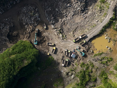 Aerial view of Tambang Pasir Merapi Kali Gendol Sand Mine with excavators trucks and workers on the rocky terrain Kecamatan Cangkringan Daerah Istimewa Yogya Indonesia. Aerial view of Tambang Pasir Merapi Kali Gendol Sand Mine with excavators trucks and workers on the rocky terrain Kecamatan Cangkringan Daerah Istimewa Yogya Indonesia.