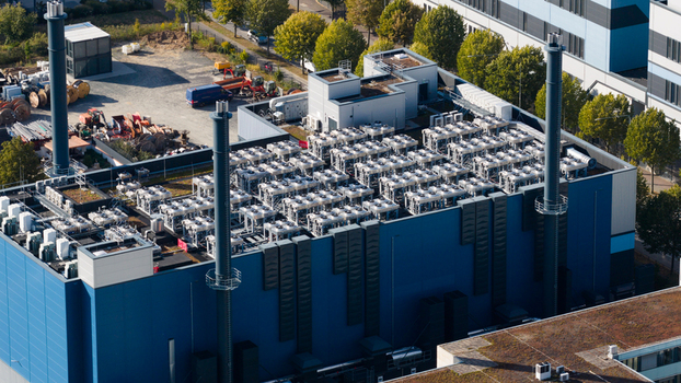 Aerial view of Sossenheim datacenters featuring industrial cooling units on the roof and tall ventilation chimneys surrounded by green trees in Frankfurt am Main Hessen Germany. Aerial view of Sossenheim datacenters featuring industrial cooling units on the roof and tall ventilation chimneys surrounded by green trees in Frankfurt am Main Hessen Germany.