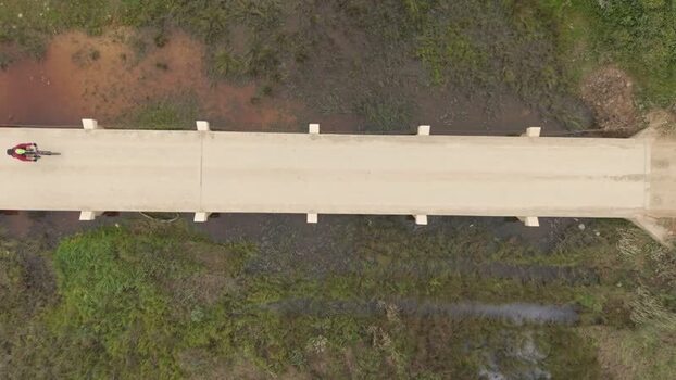 Aerial view of a cyclist crossing a bridge in South Africa. Aerial view of a cyclist crossing a bridge in South Africa.