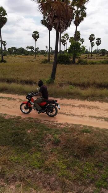 Aerial view of a motorcyclist on a dirt path in Cambodia. Aerial view of a motorcyclist on a dirt path in Cambodia.
