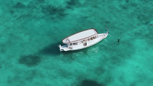 Aerial view of a white boat anchored in turquoise waters Maldives. Aerial view of a white boat anchored in turquoise waters Maldives.