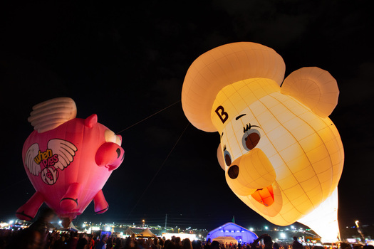 Albuquerque United States 13 October 2017 View of whimsical hot air balloons shaped like a pig and a bear glowing brightly against the dark night sky. Albuquerque United States 13 October 2017 View of whimsical hot air balloons shaped like a pig and a bear glowing brightly against the dark night sky.