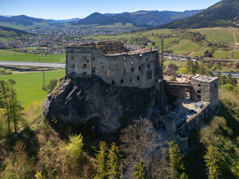 Aerial view of Castle Likava ruins perched on a rocky cliff surrounded by lush green hills and the town valley in Likavka Zilina Region Slovakia. Aerial view of Castle Likava ruins perched on a rocky cliff surrounded by lush green hills and the town valley in Likavka Zilina Region Slovakia.