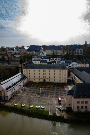 Aerial view of the historic Neumunster Abbey courtyard with its symmetrical stone paving surrounding buildings and a river flowing nearby in the city center Luxembourg Luxembourg Luxembourg.