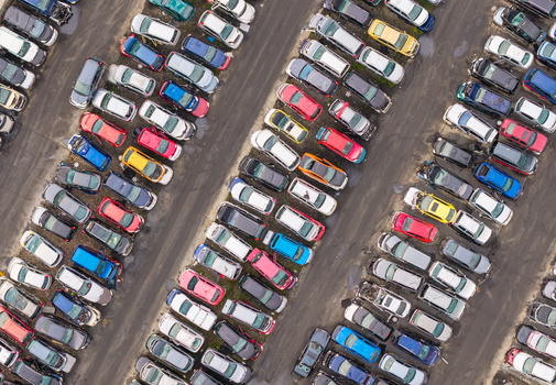 Aerial view of an end of life vehicle recycling facility with rows of parked cars in various colors asphalt lanes and industrial storage area in Gdansk Pomeranian Voivodeshi Poland.