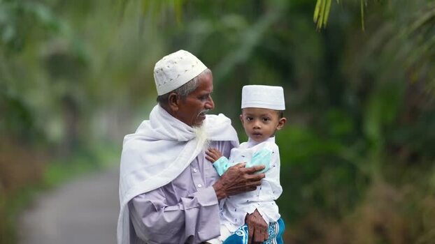 View of an elderly man holding a young boy in Bogura Bangladesh. View of an elderly man holding a young boy in Bogura Bangladesh.