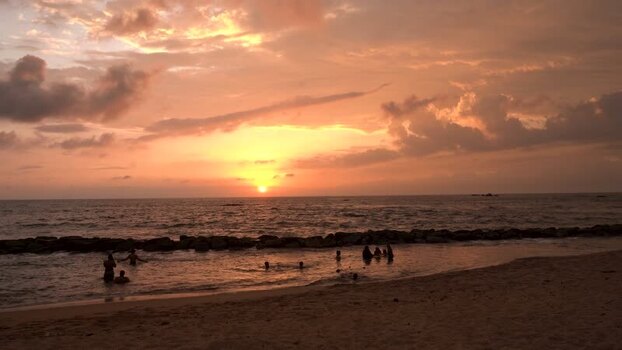 View of people swimming at sunset Sri Lanka. View of people swimming at sunset Sri Lanka.