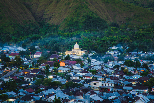 Aerial view of the village of Sembalun with its central mosque nestled in the lush green foothills of Mount Rinjani in Sembalun West Nusa Tenggara Indonesia. Aerial view of the village of Sembalun with its central mosque nestled in the lush green foothills of Mount Rinjani in Sembalun West Nusa Tenggara Indonesia.