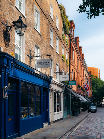 London United Kingdom 20 June 2025 View of a quiet cobblestone street lined with colorful shops and brick buildings under a bright sky capturing the essence of London s architectural charm. London United Kingdom 20 June 2025 View of a quiet cobblestone street lined with colorful shops and brick buildings under a bright sky capturing the essence of London s architectural charm.