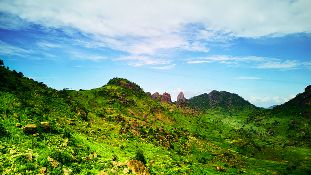 Aerial view of the rocky hills and lush green landscape of the Dass region under a bright blue sky in Bauchi Bauchi Nigeria.