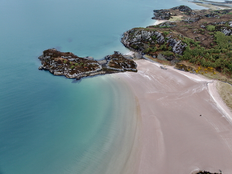 Aerial view of the turquoise waters and sandy shores of Gruinard Bay with rocky outcrops and green hills in Gruinard Scotland United Kingdom. Aerial view of the turquoise waters and sandy shores of Gruinard Bay with rocky outcrops and green hills in Gruinard Scotland United Kingdom.