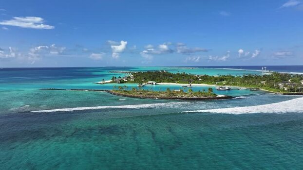 Aerial view of a resort island and coral reefs Maldives.